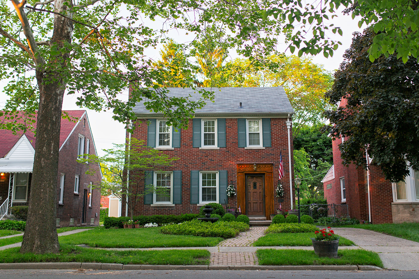 Classic red-brick colonial home with blue shutters in Detroit’s East English Village